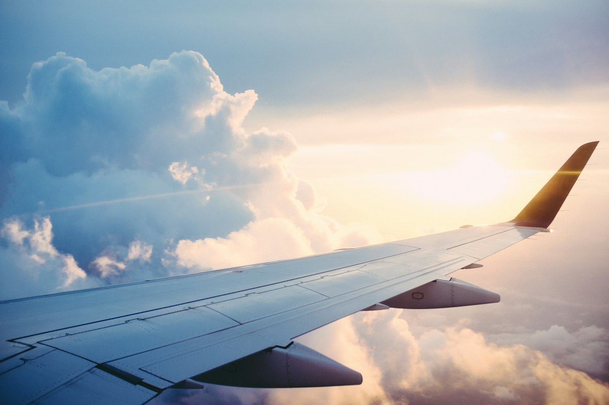 An aircraft flying above the clouds, representing international travel.